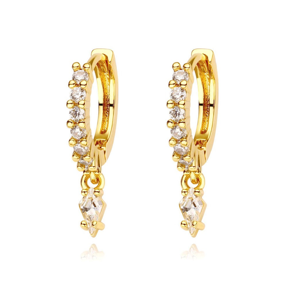 Gold hoop earrings with diamond-like stones on a white background