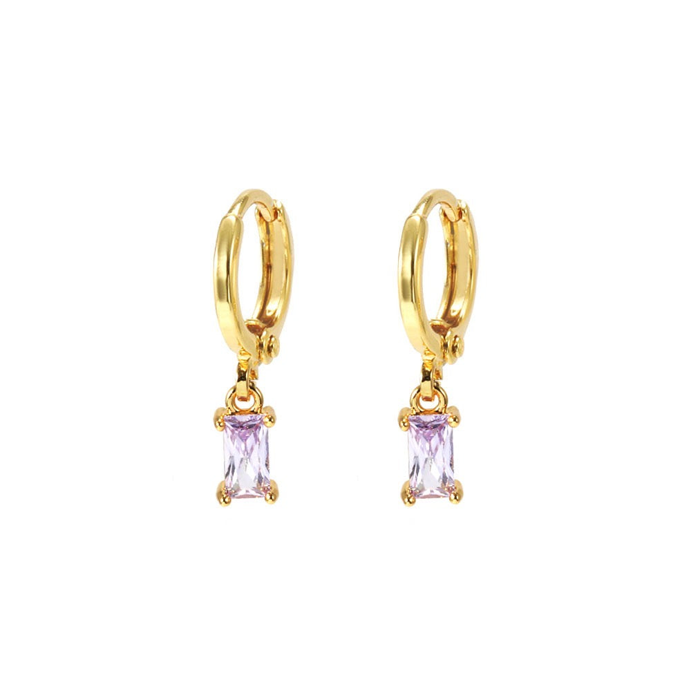 Gold hoop earrings with purple gemstones on a white background