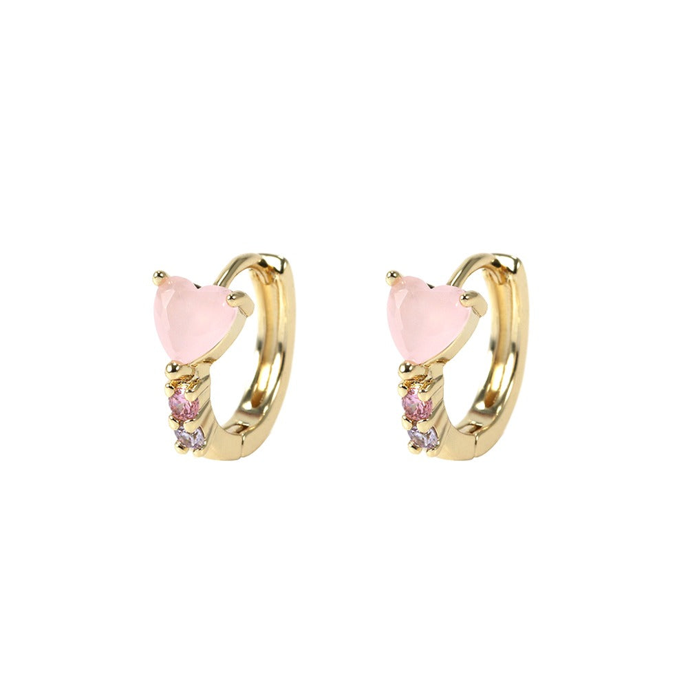 Gold hoop earrings with pink heart-shaped stones on a white background